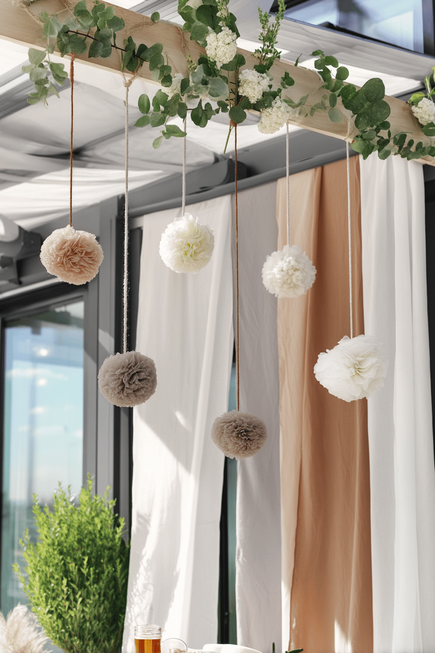 Hängende Pompons und Stoffbahnen zieren eine Terrasse für eine Hochzeit.